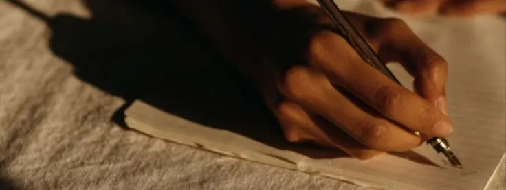 main qui écrit avec un stylo plume