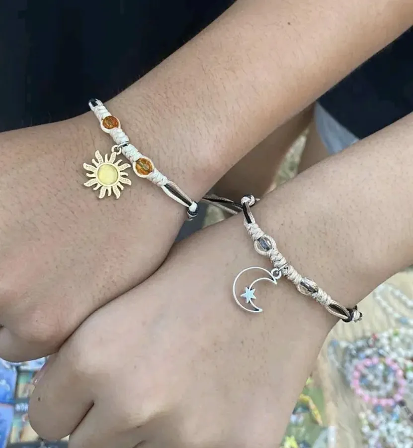 Deux bracelets semblables, un au pendantif de soleil et un au pendantif de lune